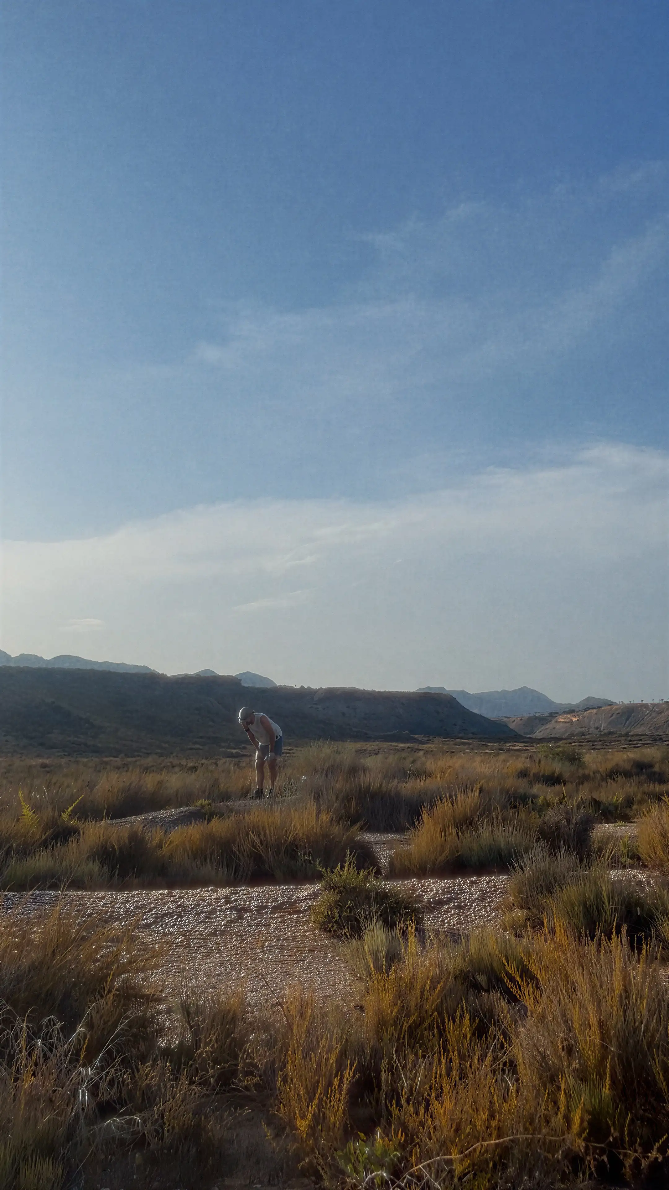 Diego DPL, diminuto en mitad de unos badlands, con las manos en las rodillas después de correr